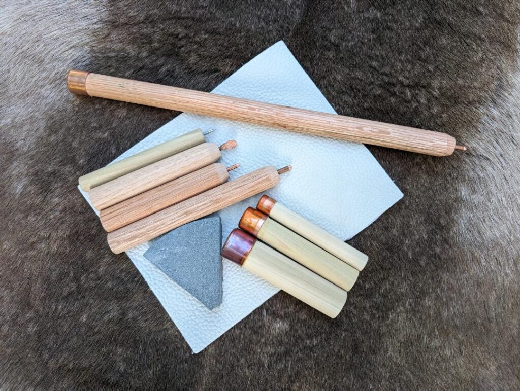 Lot - Lot including a Basic Flint Knapping Kit (1 leather palm protector, 1  hammer stone, 4 pieces of flint and 2 copper tipped pressure chippers) and  a fandex of facts about 50 Native American tribes.